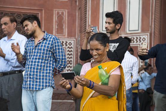 Intialainen nainen kuvaa kännykällä